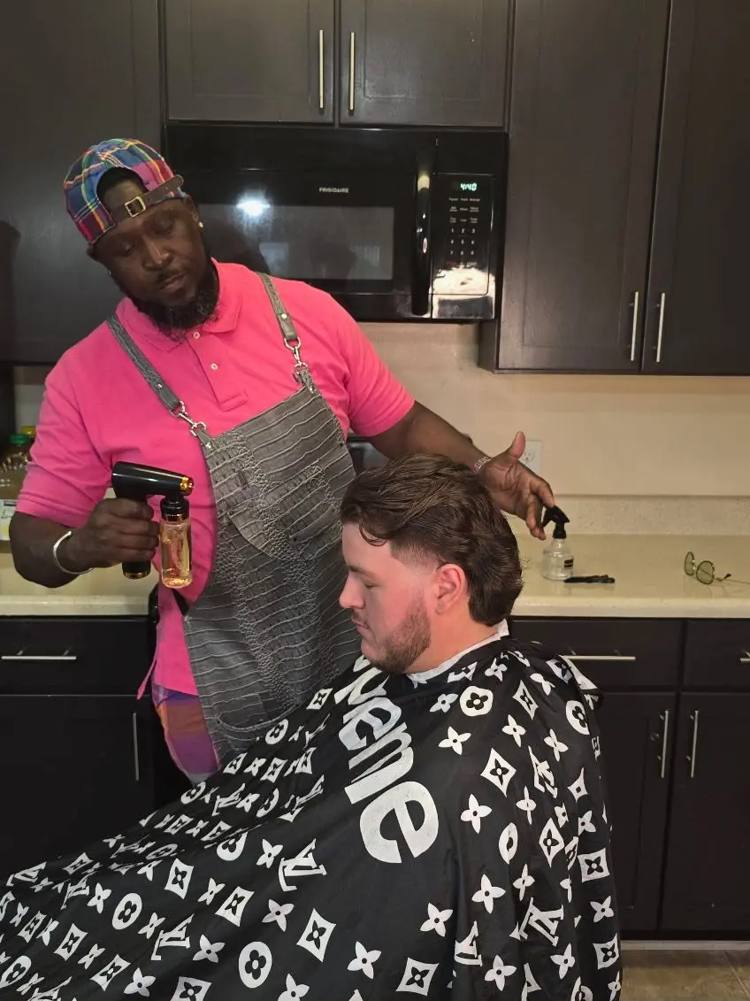 Rece styling a client during a mobile barbering appointment