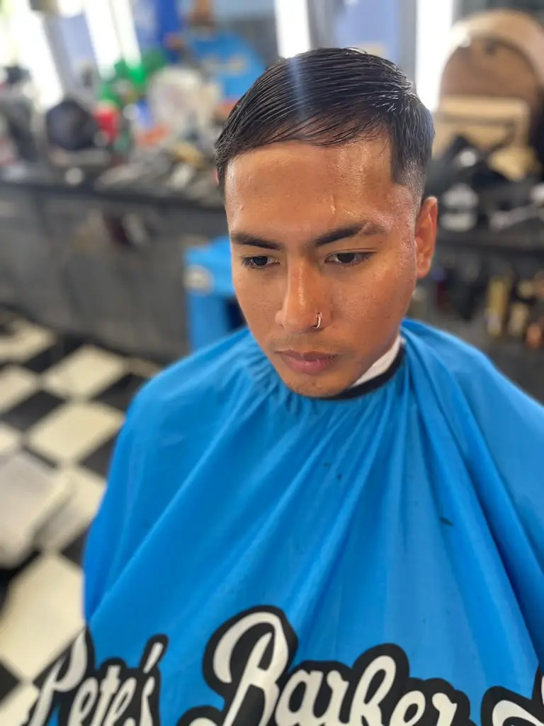 Finished haircut with a clean side part and fade